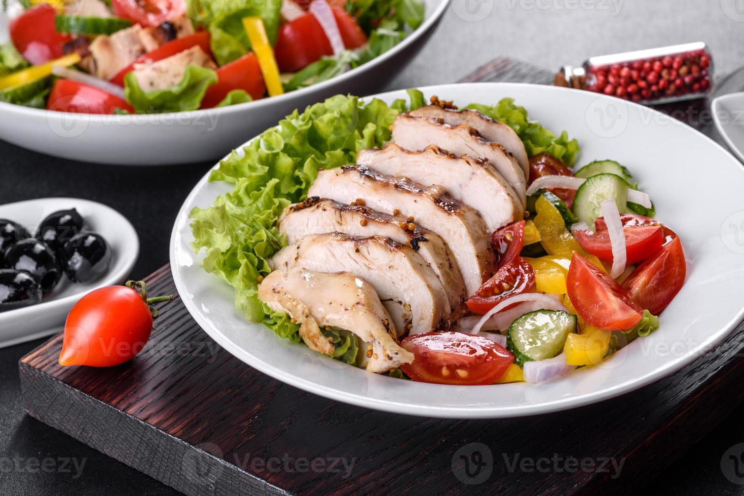 Fresh delicious salad with chicken, tomato, cucumber, onions and greens with olive oil photo