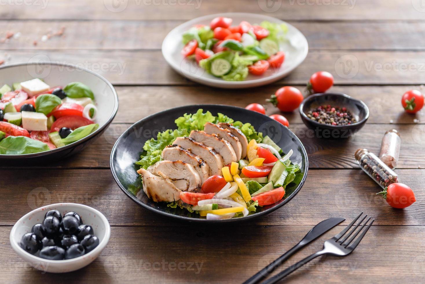 deliciosa ensalada fresca con pollo, tomate, pepino, cebolla y verduras con aceite de oliva foto