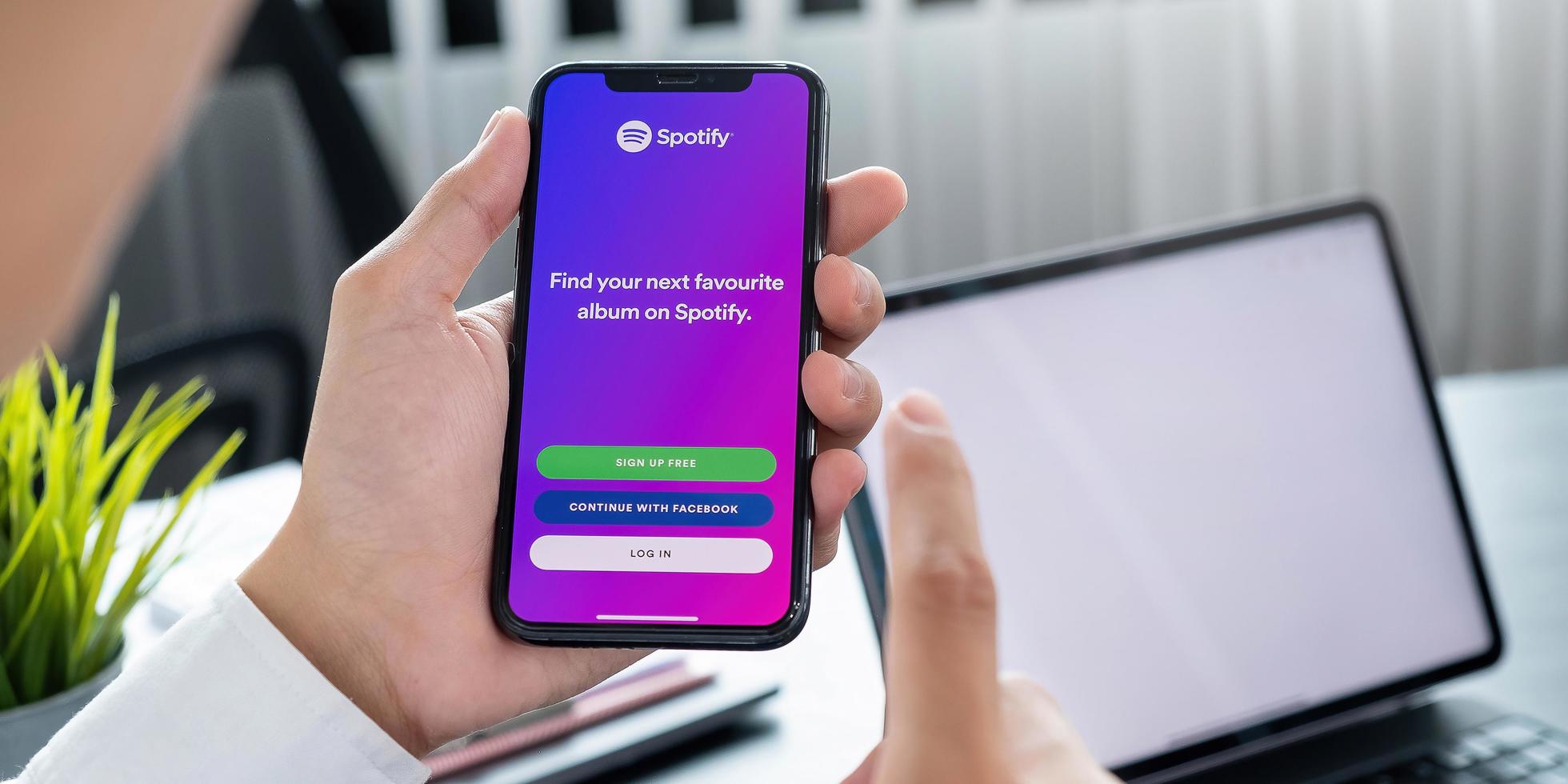 Person holding a brand new Apple iPhone XS with Spotify logo on the screen photo