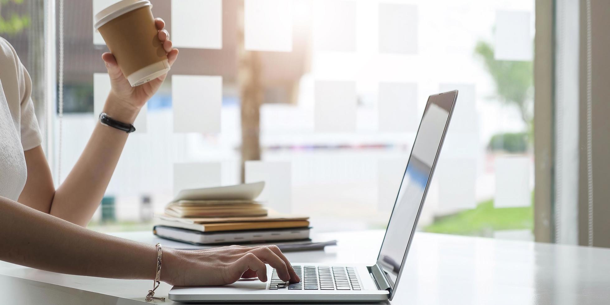 Female employee using laptop at workplace photo