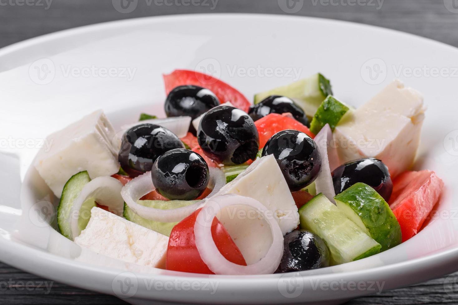 deliciosa ensalada griega fresca con tomate, pepino, cebolla y aceitunas con aceite de oliva foto