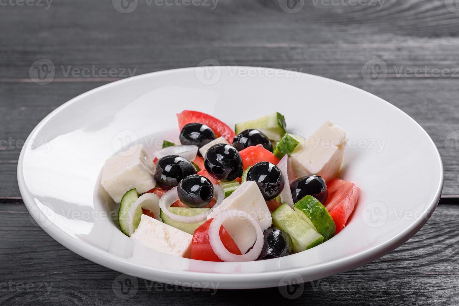 deliciosa ensalada griega fresca con tomate, pepino, cebolla y aceitunas con aceite de oliva foto