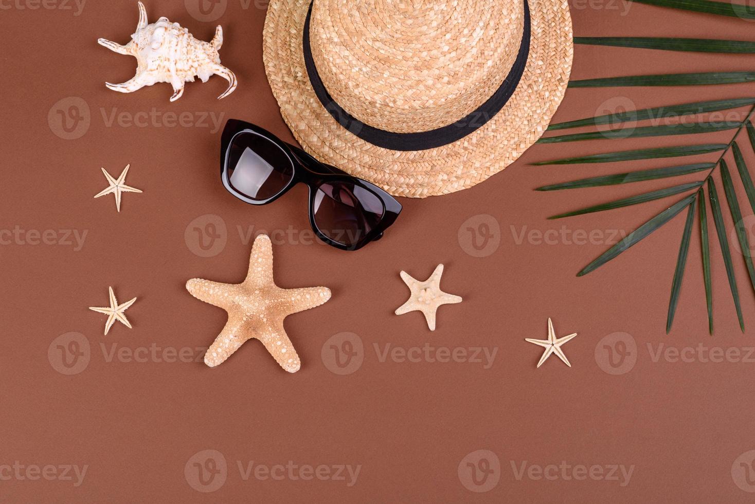 accesorios de playa, gafas y sombrero con conchas y estrellas de mar sobre un fondo de color. fondo de verano foto
