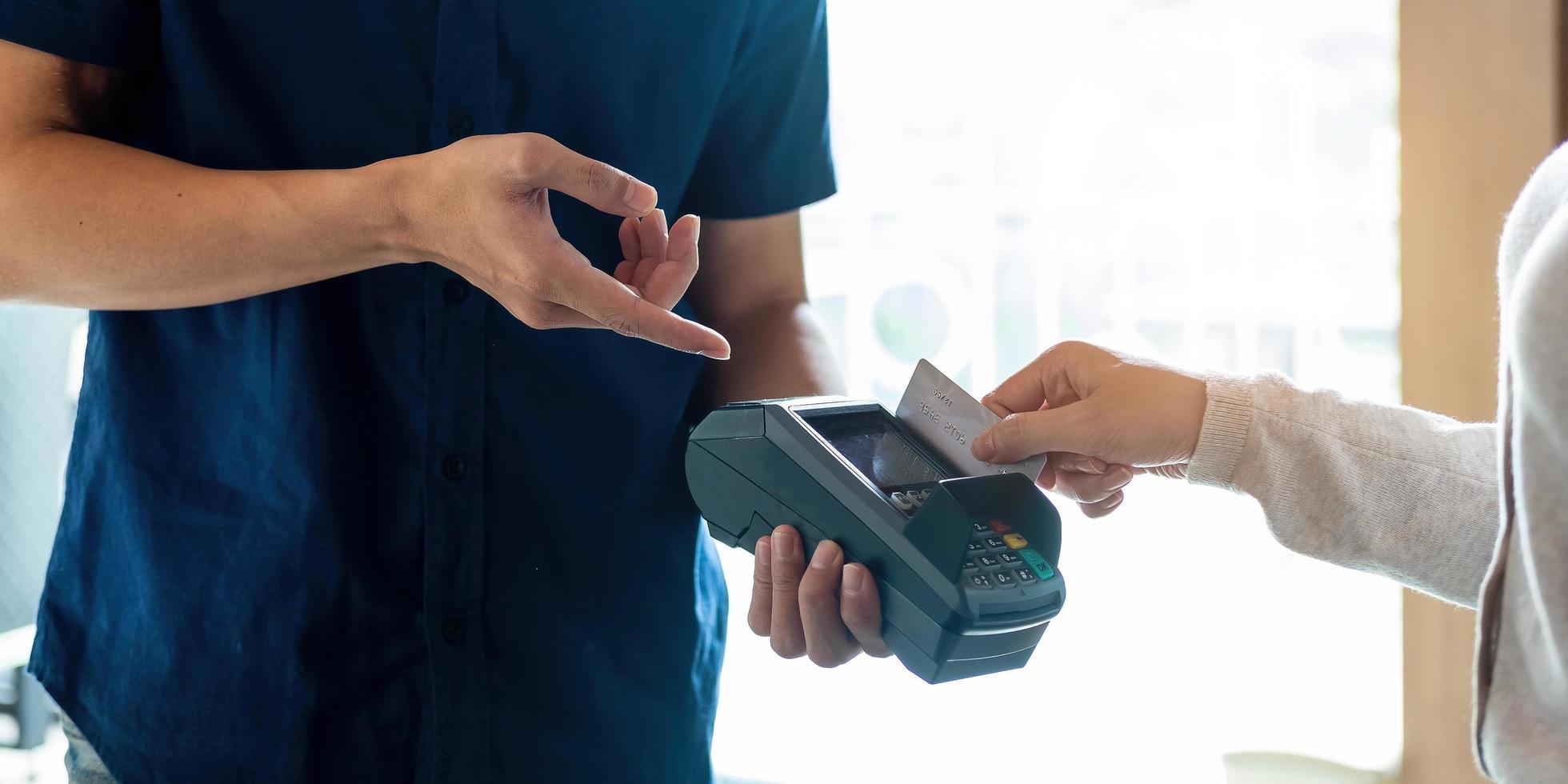 Close up of hand of customer paying with credit card photo