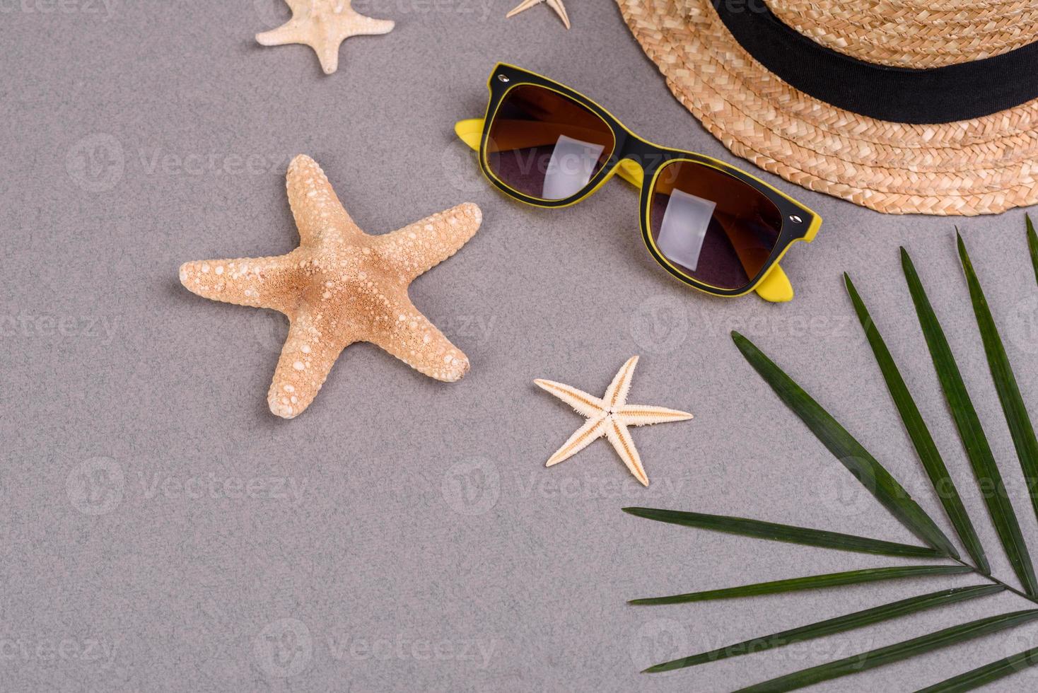 Beach accessories, glasses and hat with shells and sea stars on a colored background. Summer background photo