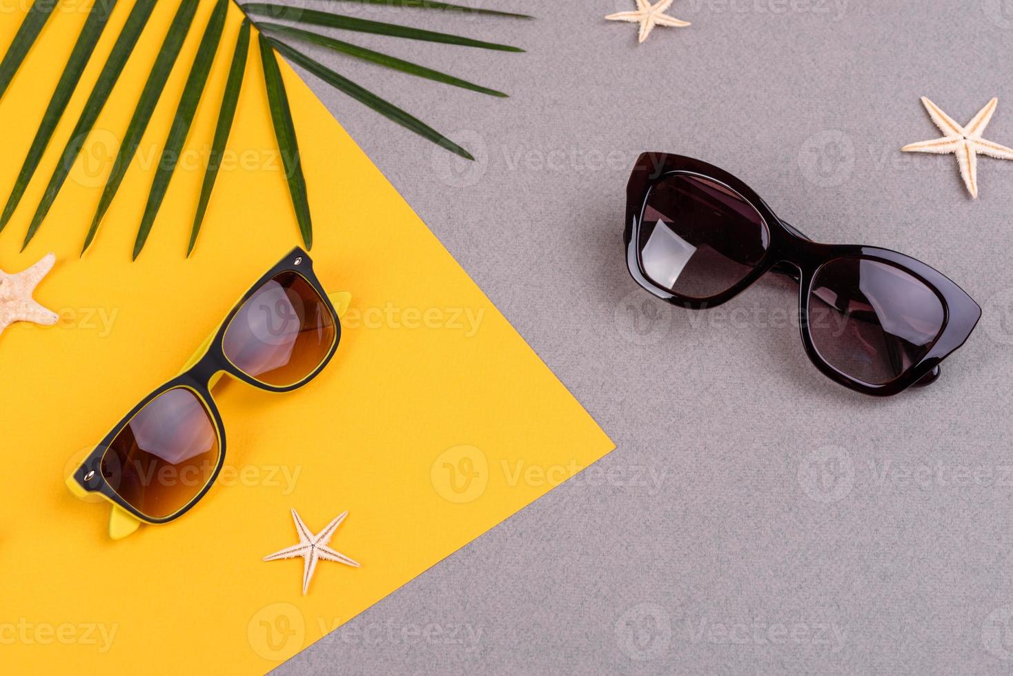 accesorios de playa, gafas y sombrero con conchas y estrellas de mar sobre un fondo de color. fondo de verano foto