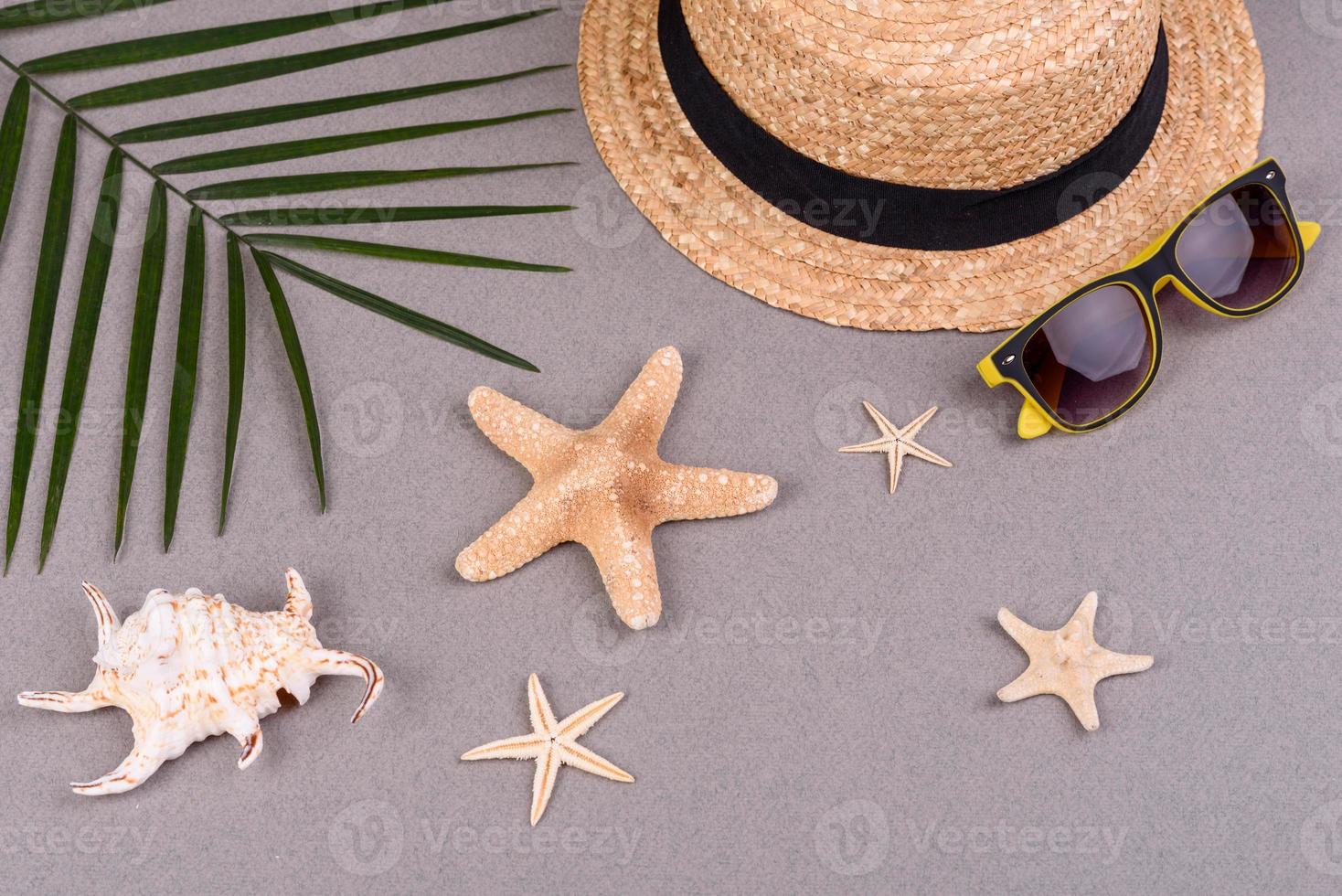 Beach accessories, glasses and hat with shells and sea stars on a colored background. Summer background photo