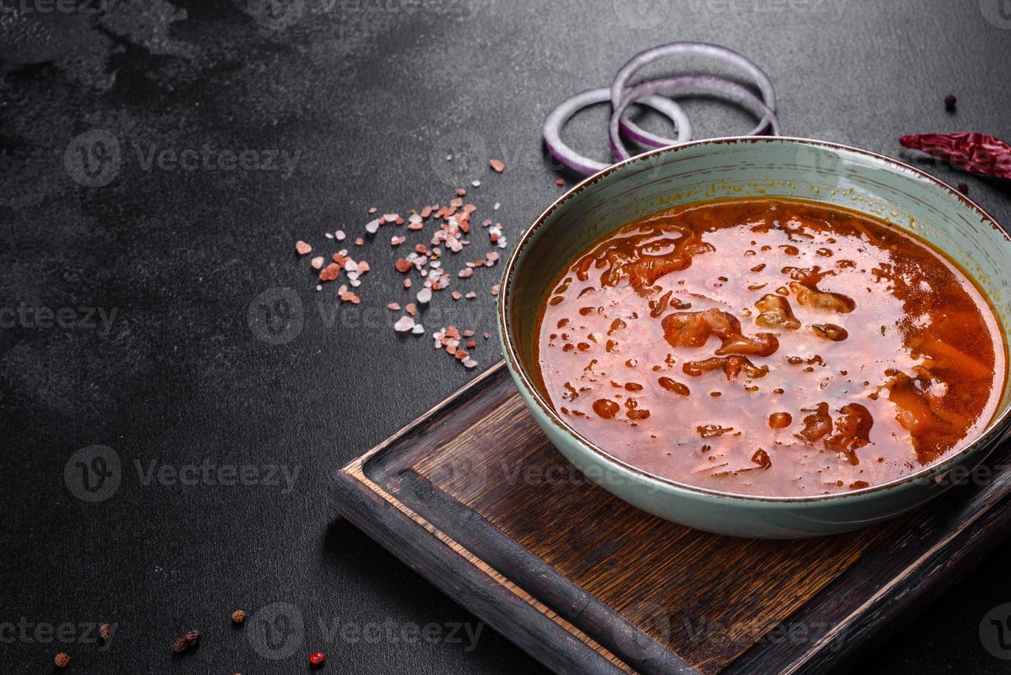 Delicious fresh hot borsch with tomato and meat in a ceramic plate photo