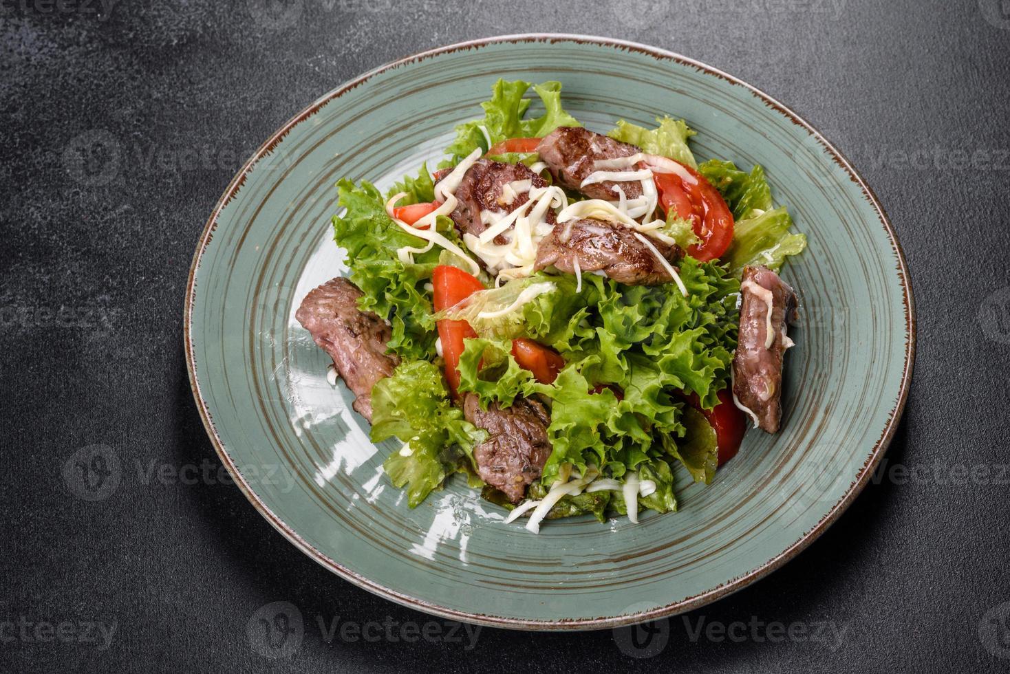 Delicious fresh salad with beef, cheese, tomatoes and lettuce leaves photo