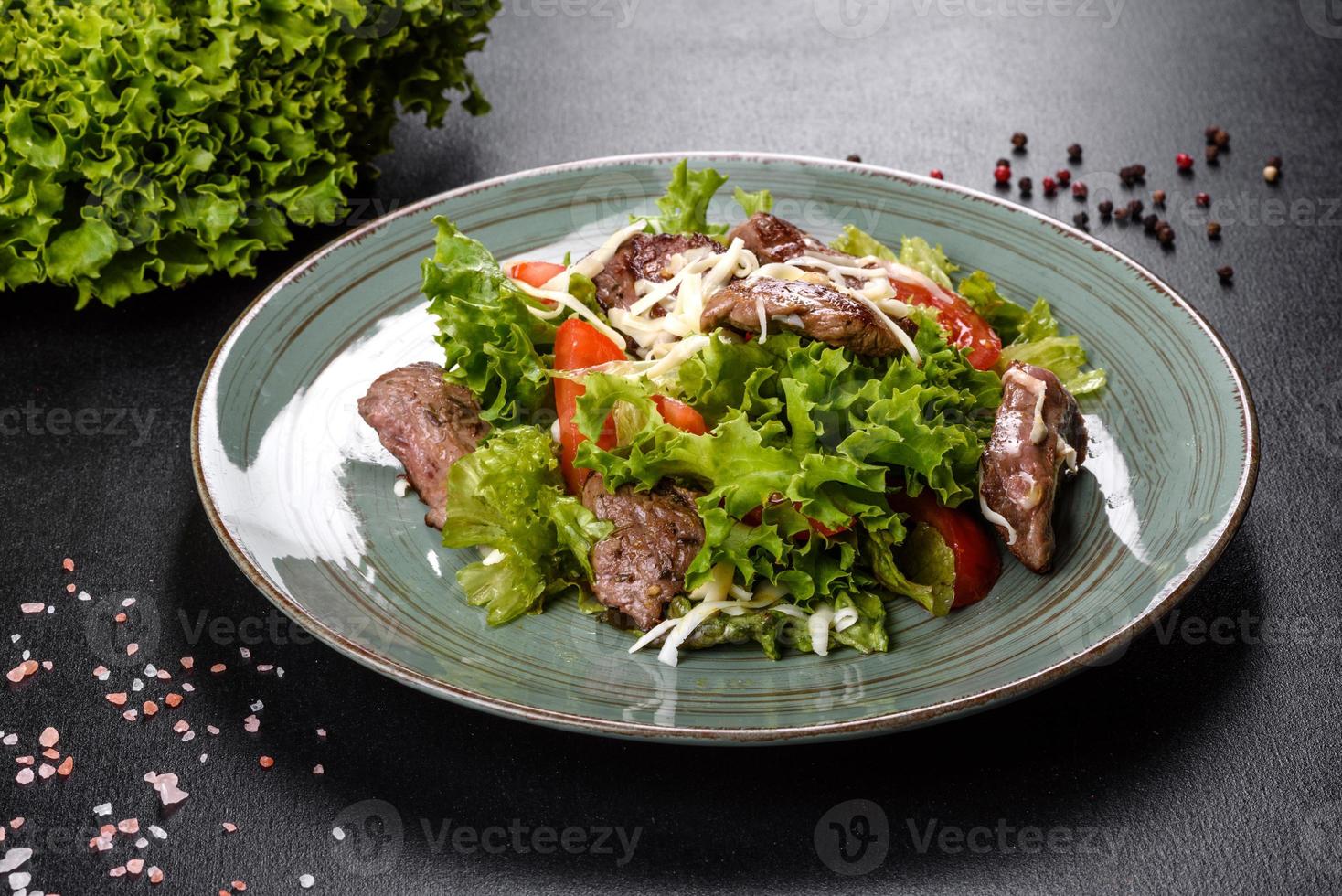 Delicious fresh salad with beef, cheese, tomatoes and lettuce leaves photo