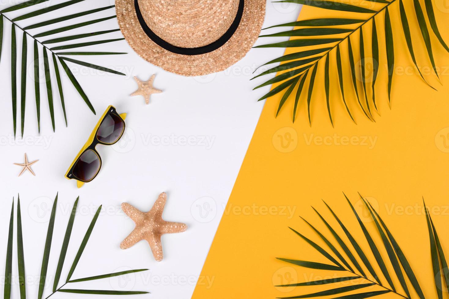 Beach accessories, glasses and hat with shells and sea stars on a colored background photo