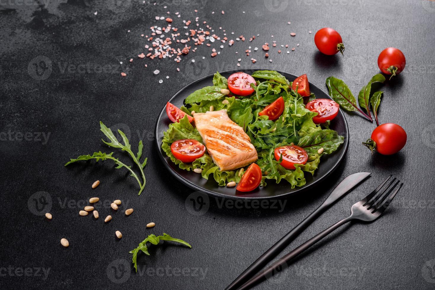 Delicious fresh salad with fish, tomatoes and lettuce leaves photo