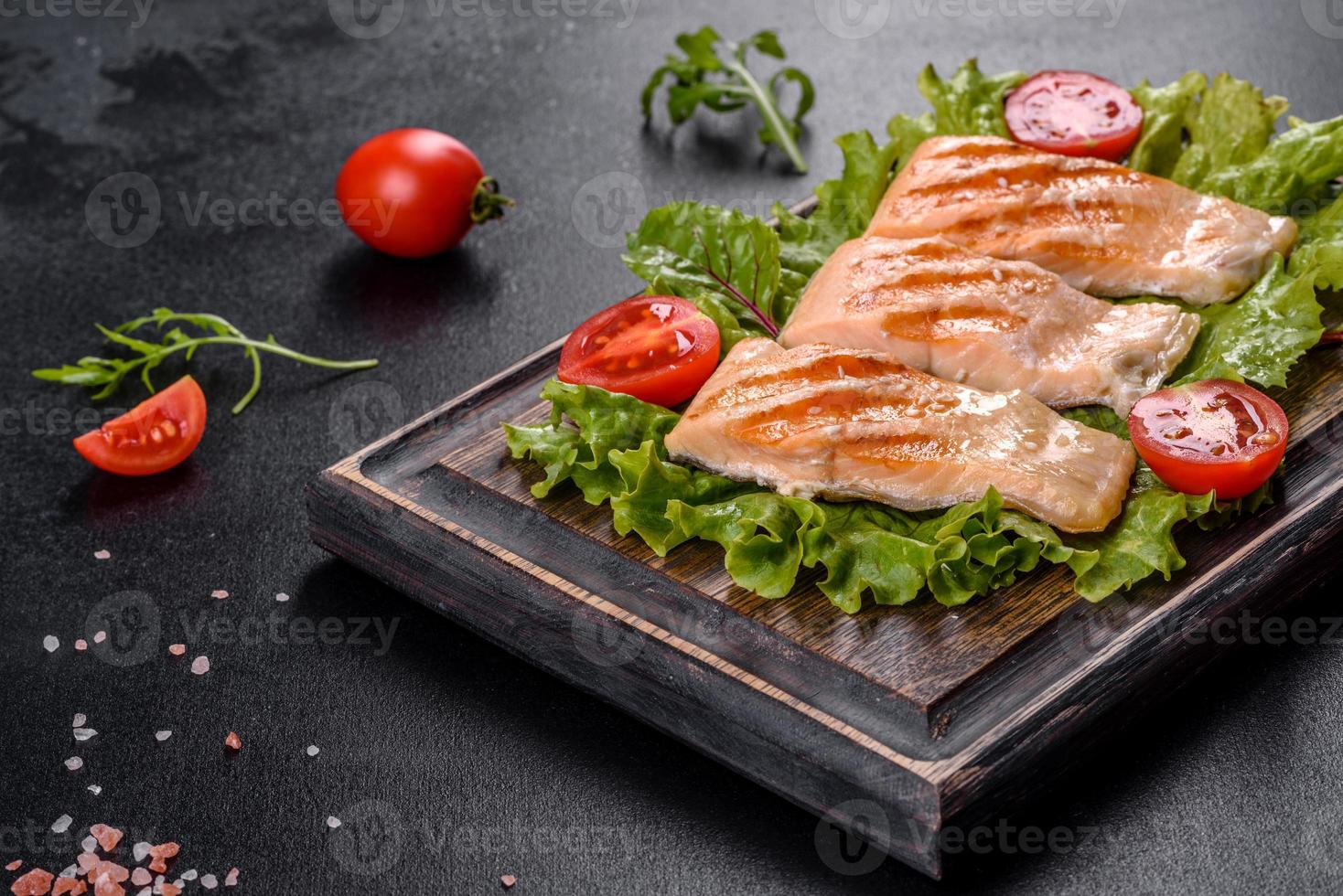 Delicious fresh salad with fish, tomatoes and lettuce leaves photo