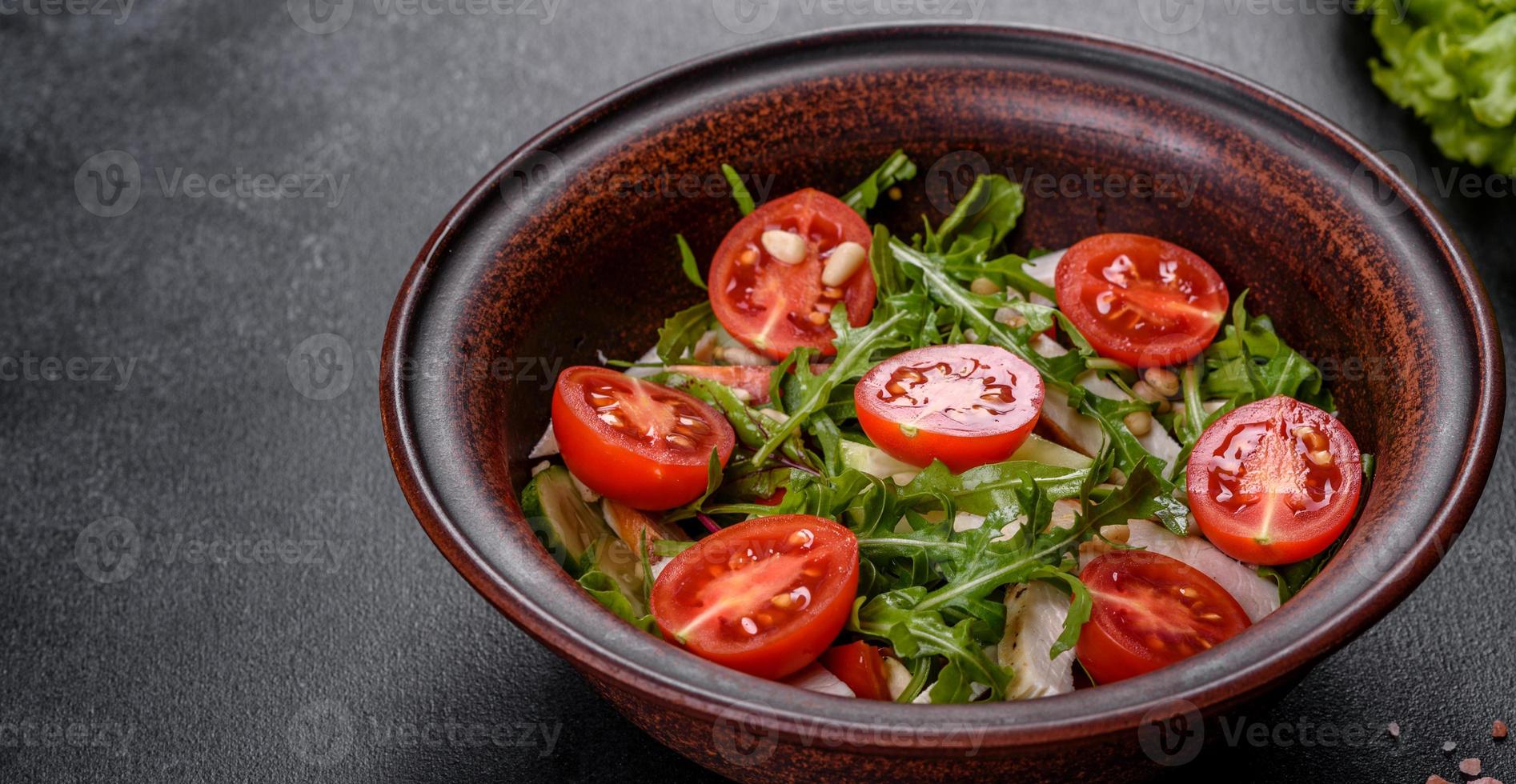 Pieces of chicken, tomatoes and lettuce leaves on a dark concrete background photo