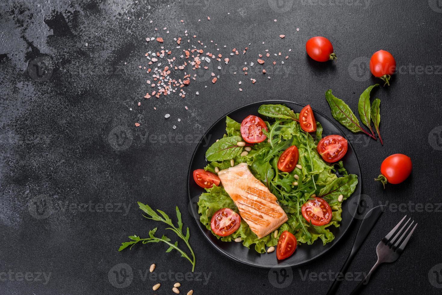 Delicious fresh salad with fish, tomatoes and lettuce leaves photo