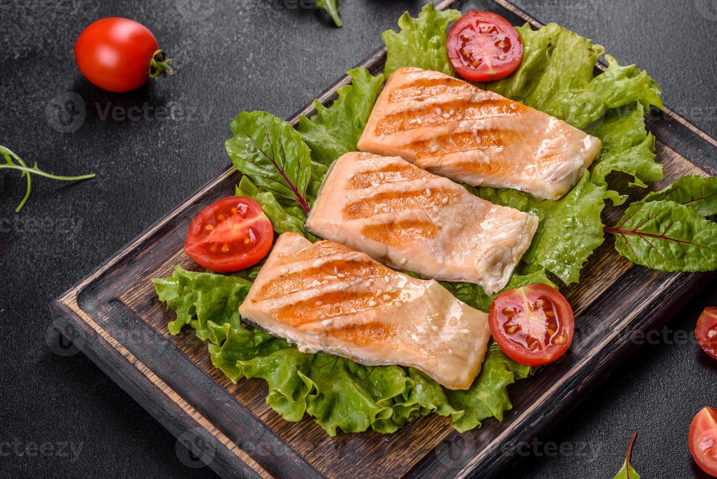 Delicious fresh salad with fish, tomatoes and lettuce leaves photo