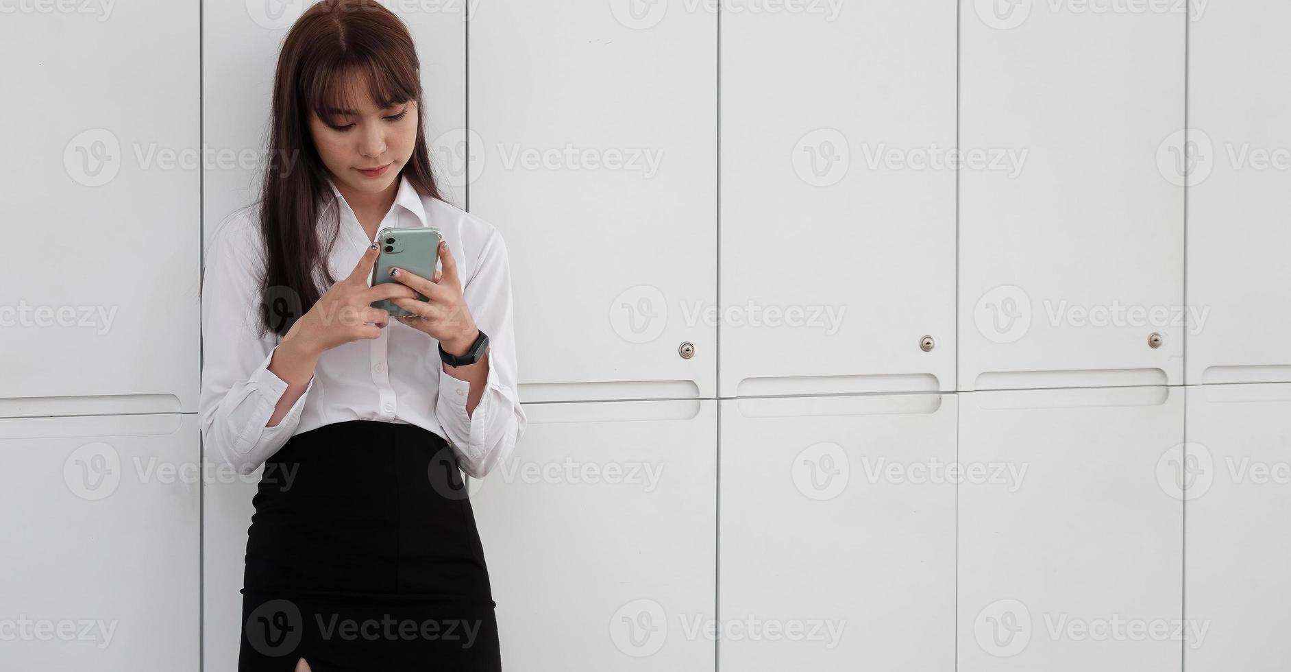 Girl standing and using mobile phone photo