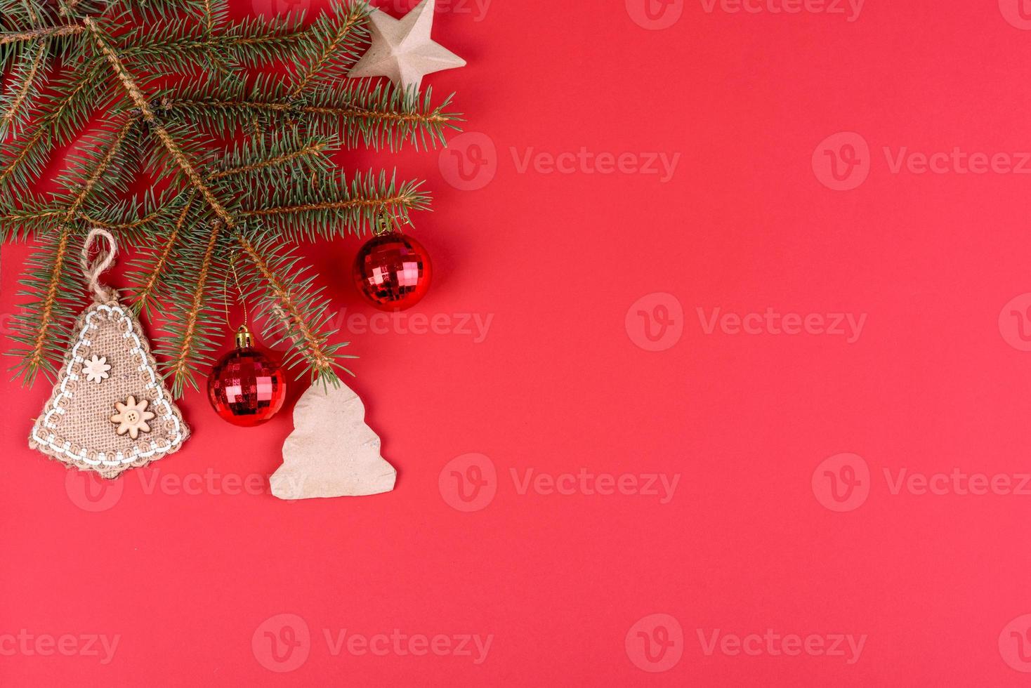 adornos navideños rojos, ramas de abeto sobre fondo rojo foto
