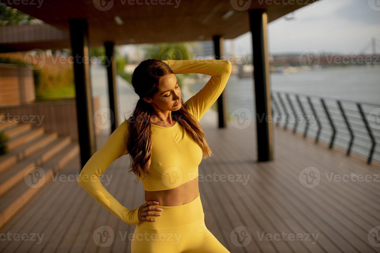 mujer joven que se extiende a la orilla del río foto