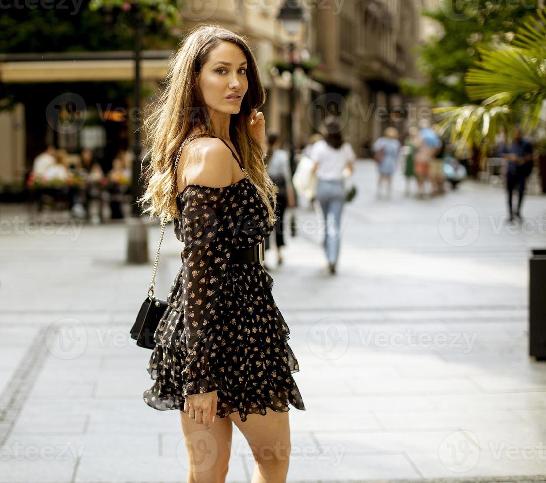 Young long hair brunette woman walking on the street photo