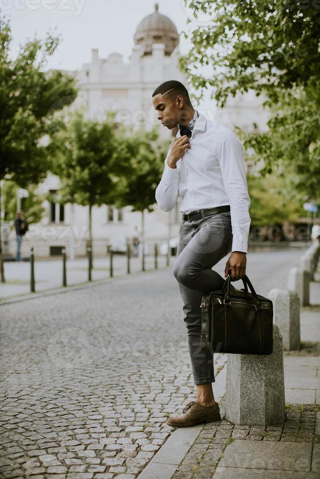 Young African American businessman waitng a taxi on a street photo