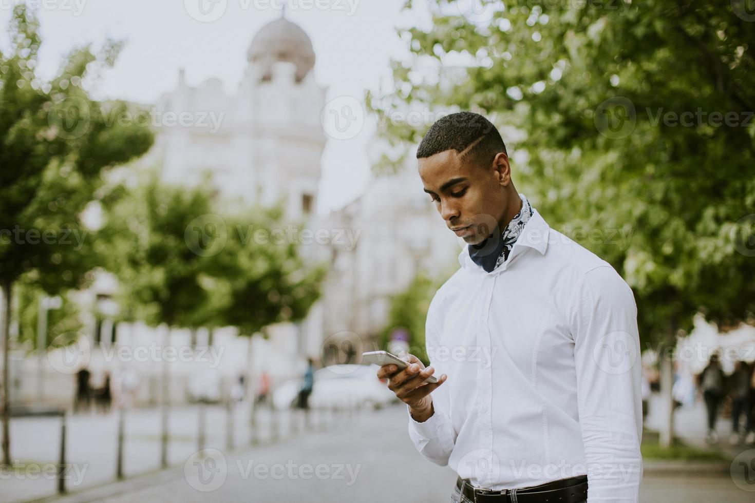 joven empresario afroamericano usando un teléfono móvil foto