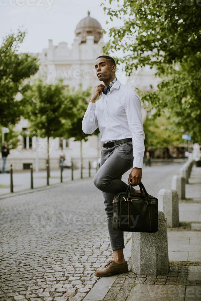 Young African American businessman waitng a taxi on a street photo