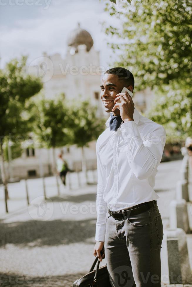 joven empresario afroamericano usando un teléfono móvil foto