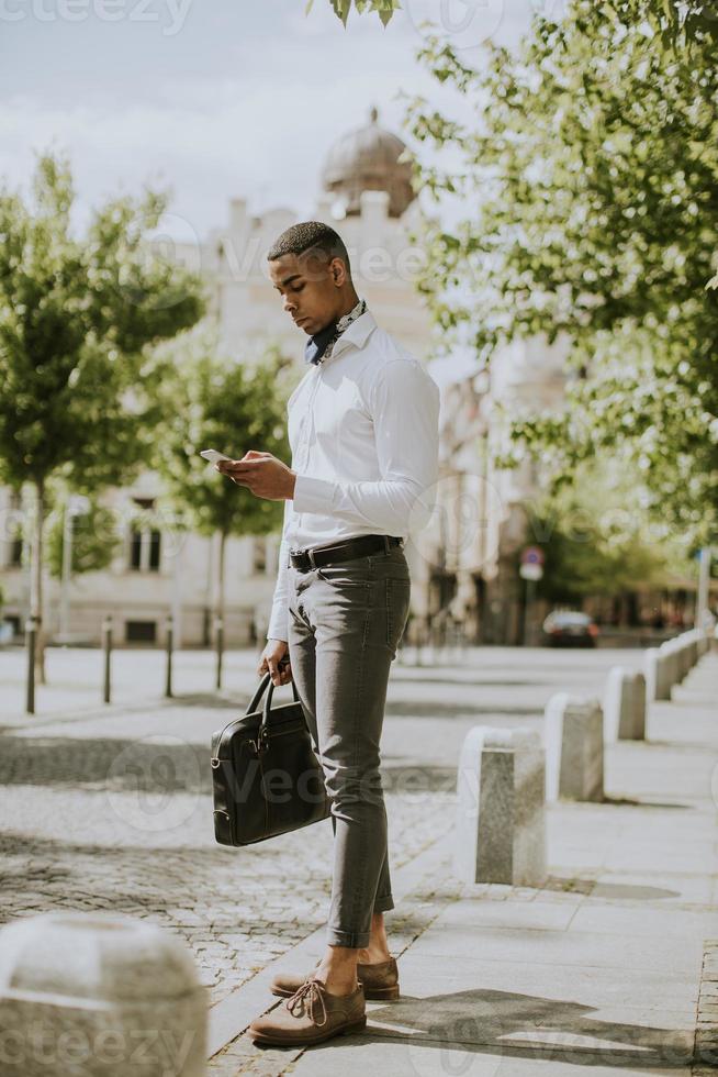 joven empresario afroamericano usando un teléfono móvil foto