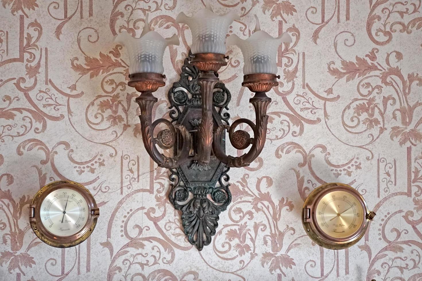 Vintage background with a beautiful sconce and barometers on the wall photo