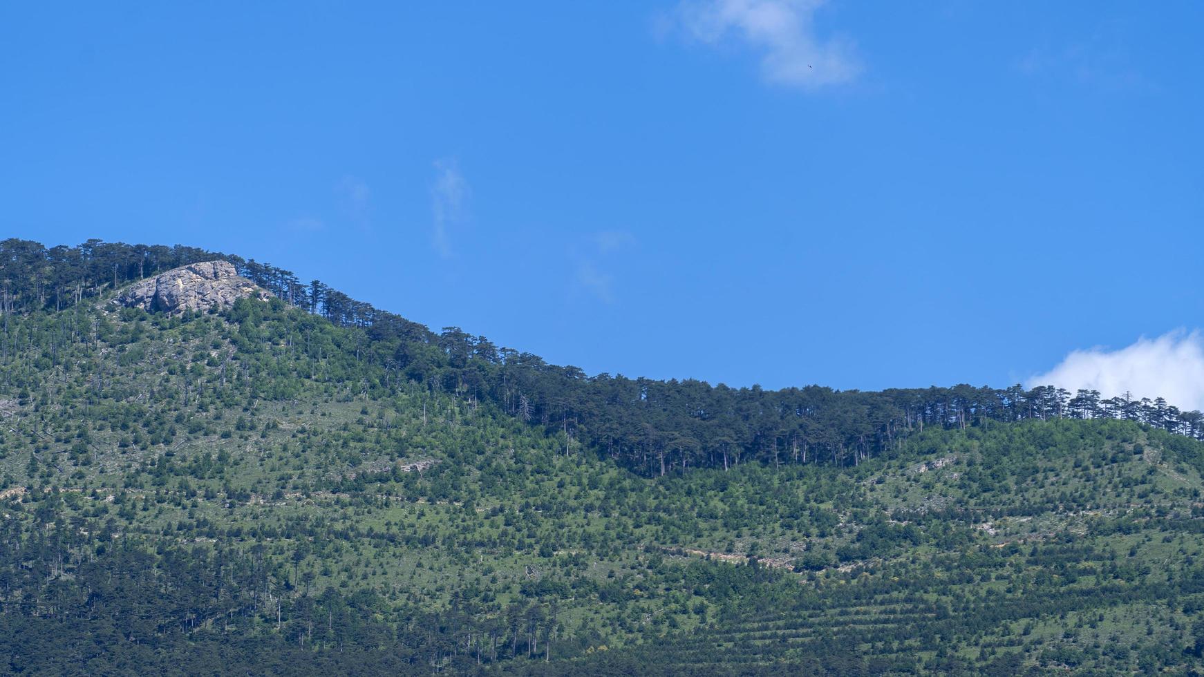 Landscape with a white cloud on the background of a mountain and a sky photo