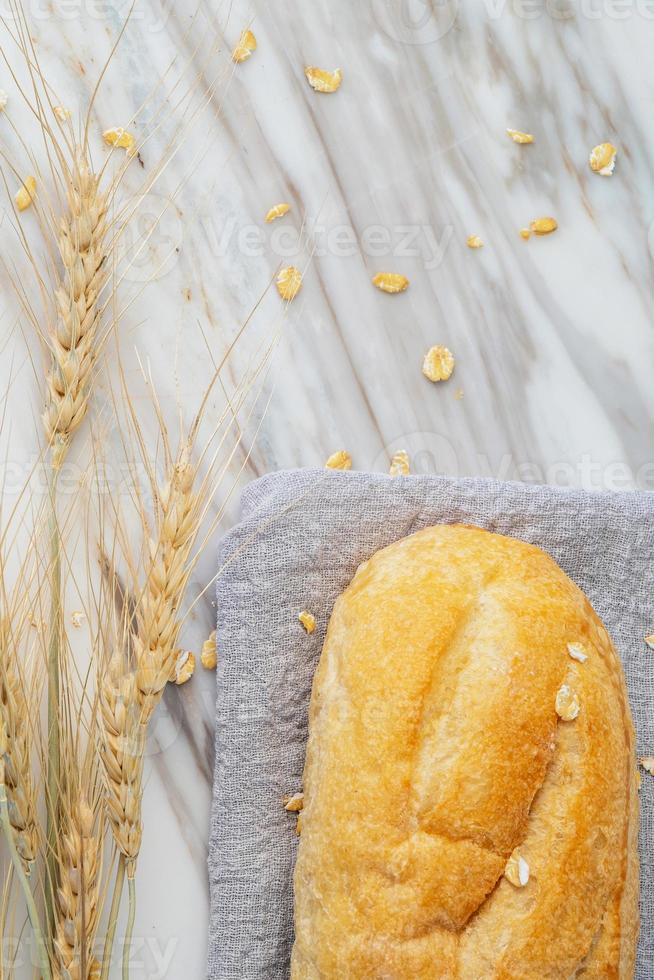 Delicious fresh baked bread on marble background. Healthy diet lifestyle. photo