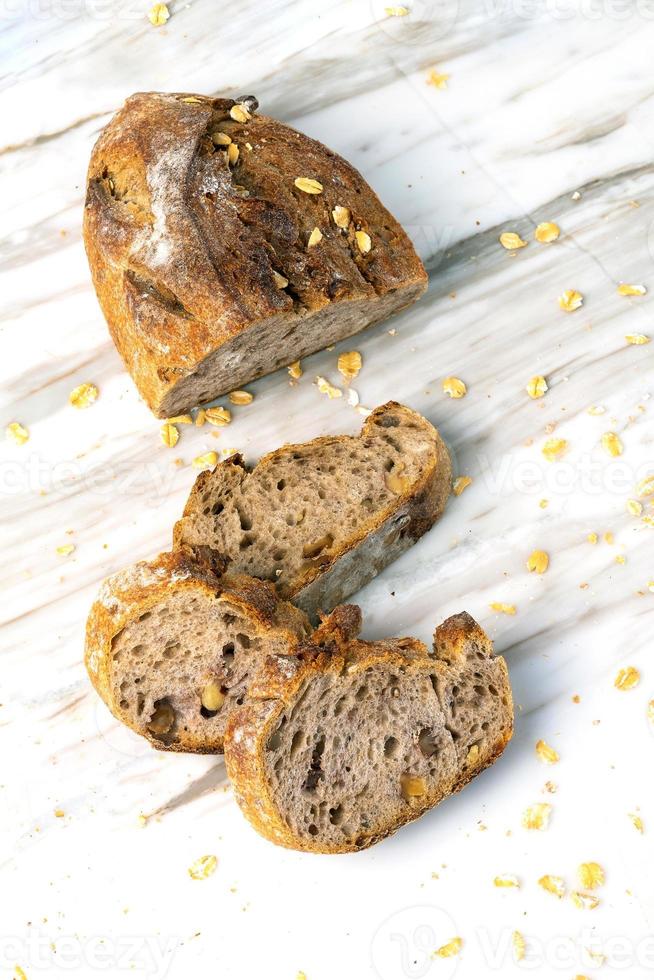 Delicious fresh baked bread on marble background. Healthy diet lifestyle. photo