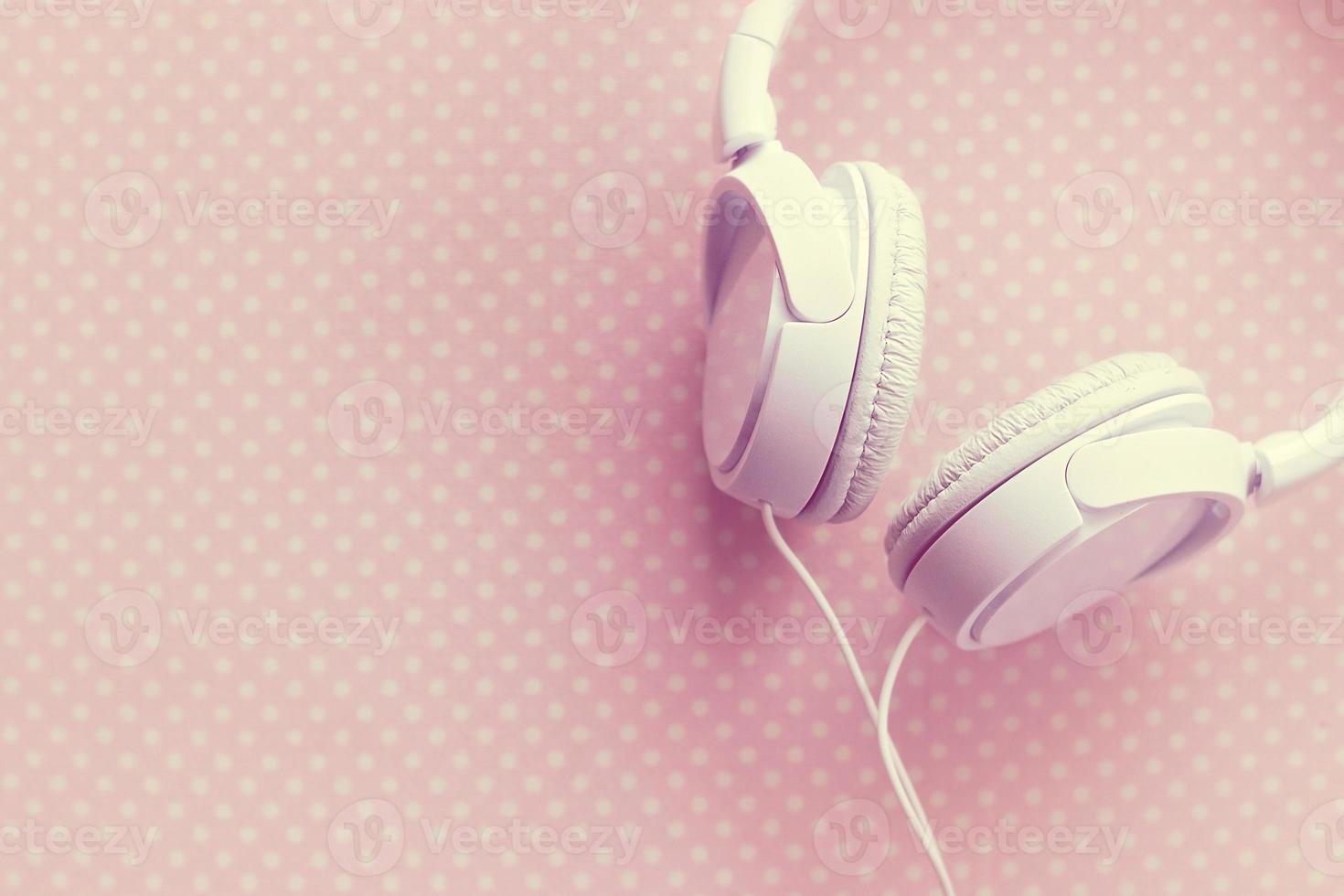 White headphones on pink background photo