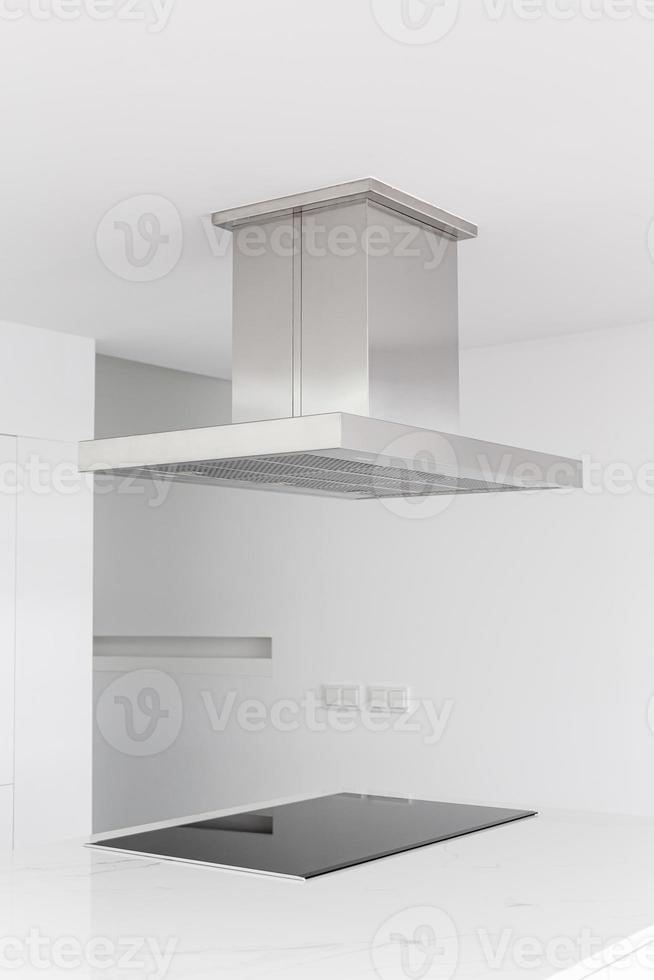 Cooker hood and electric stove of a modern and minimalist kitchen photo