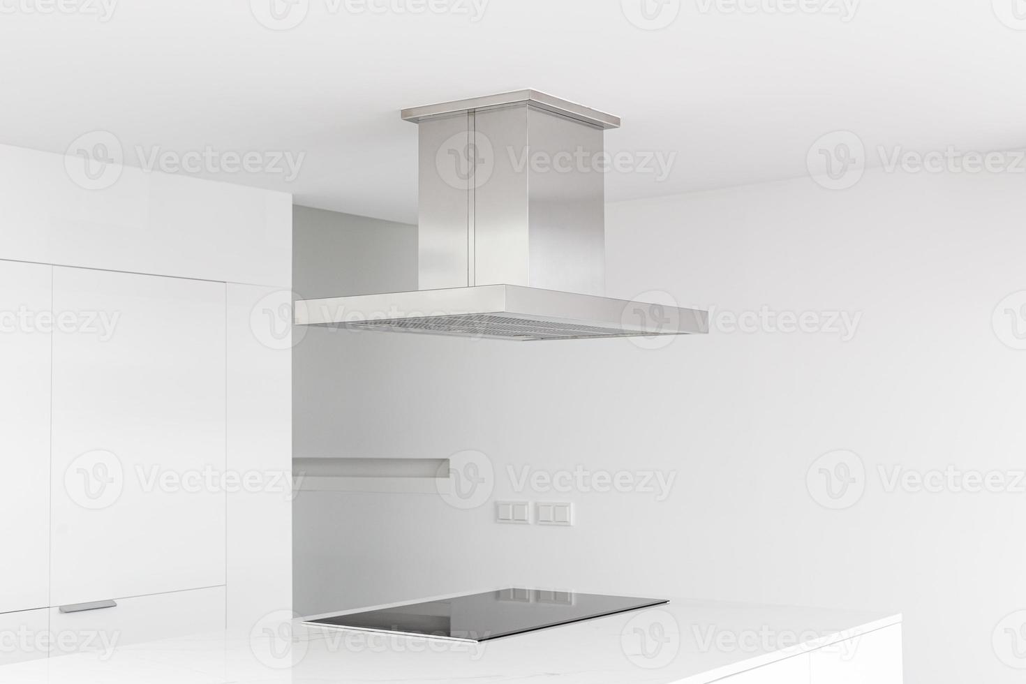 Cooker hood and electric stove of a modern and minimalist kitchen photo