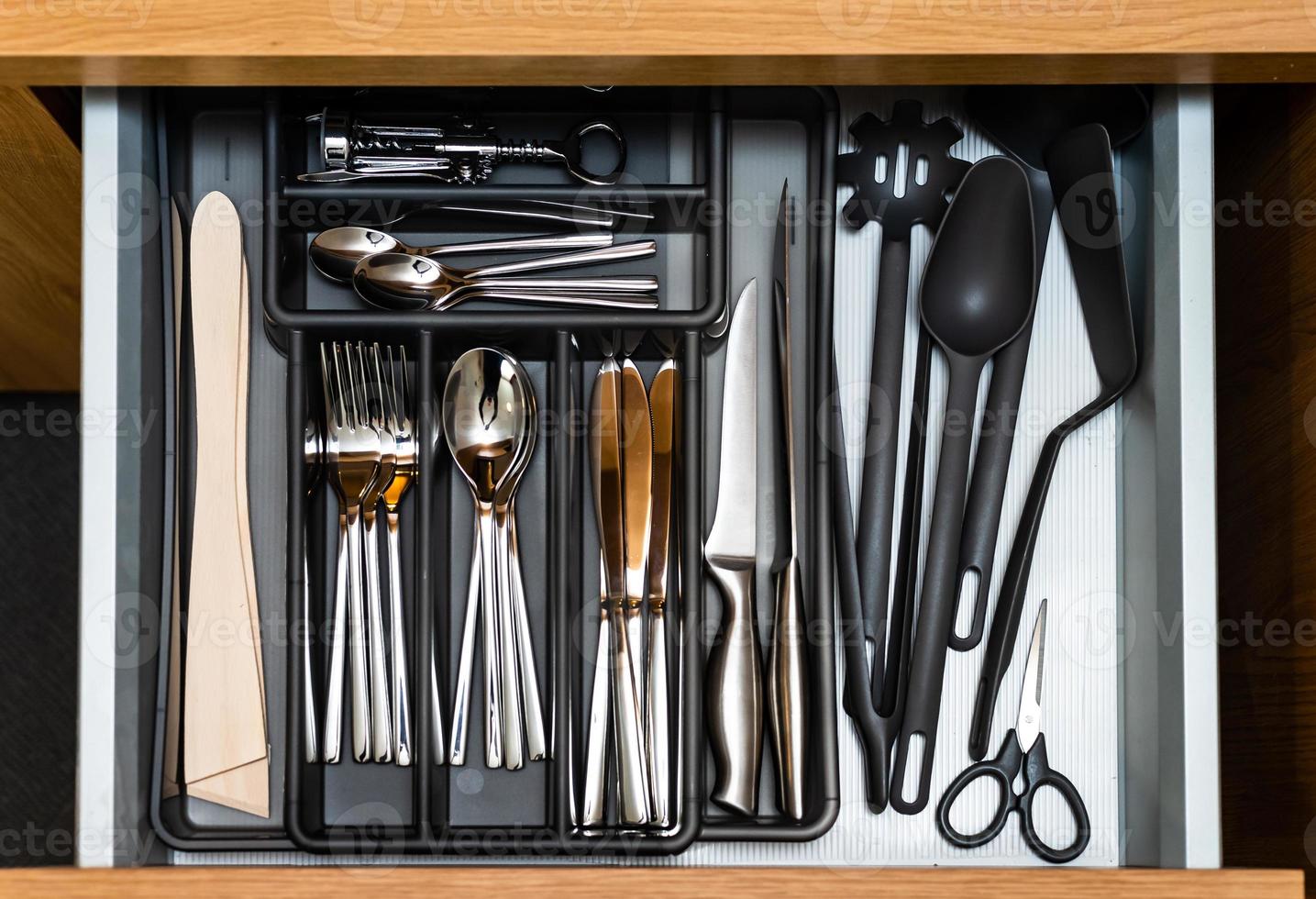 Caja de cocina con cubertería. cucharas, tenedores, cuchillos, ollas. foto