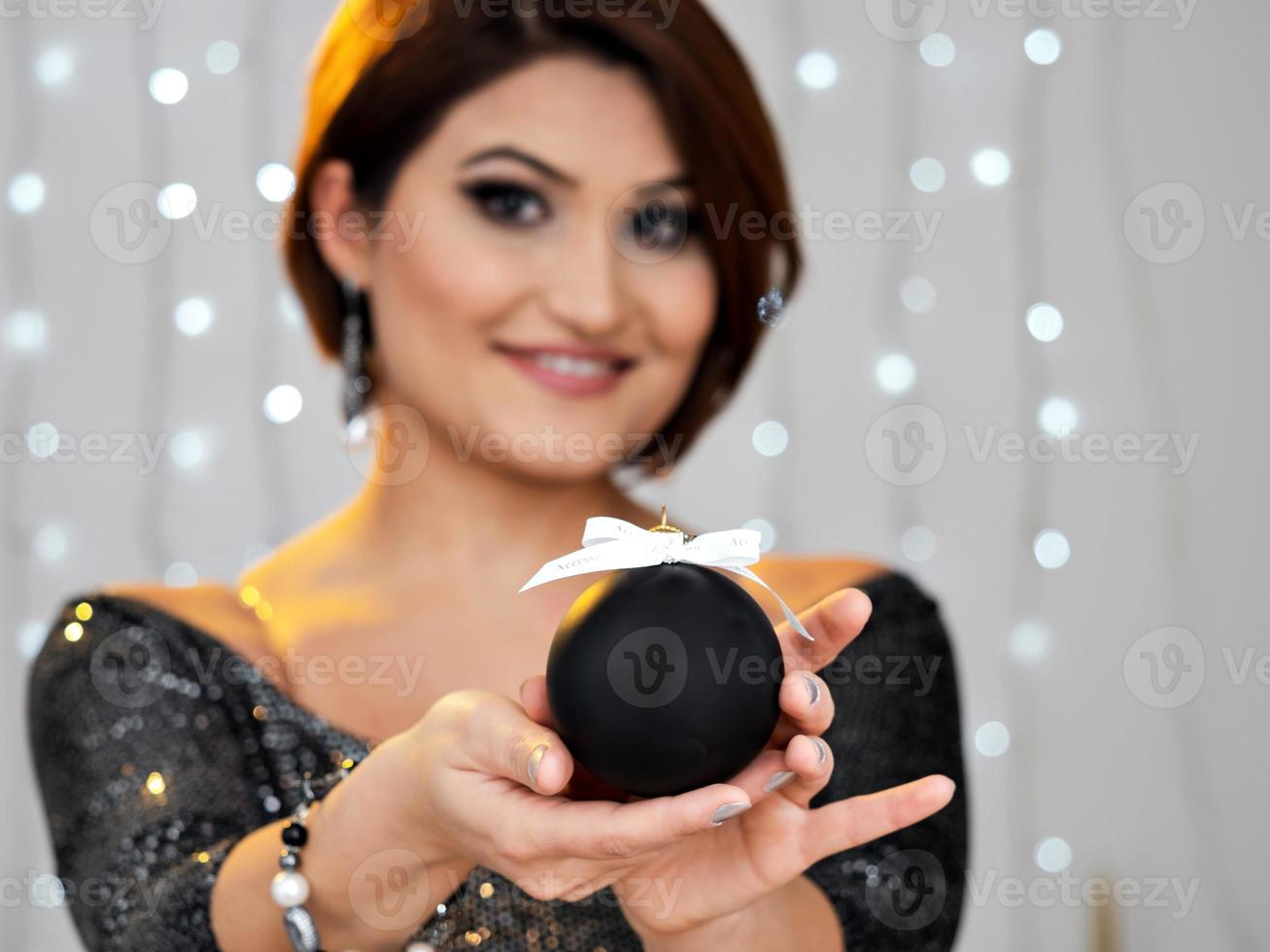 Christmas shooting. Beautiful model with New Year's gifts on background of a Christmas tree. photo