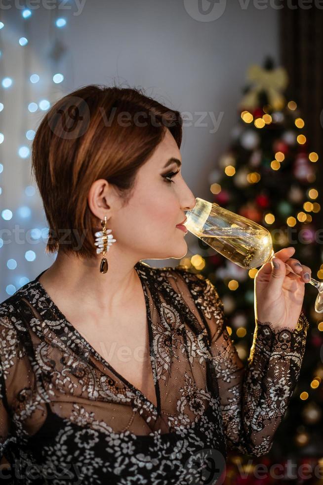 tiroteo navideño. hermosa modelo con regalos de año nuevo en el fondo de un árbol de Navidad. foto