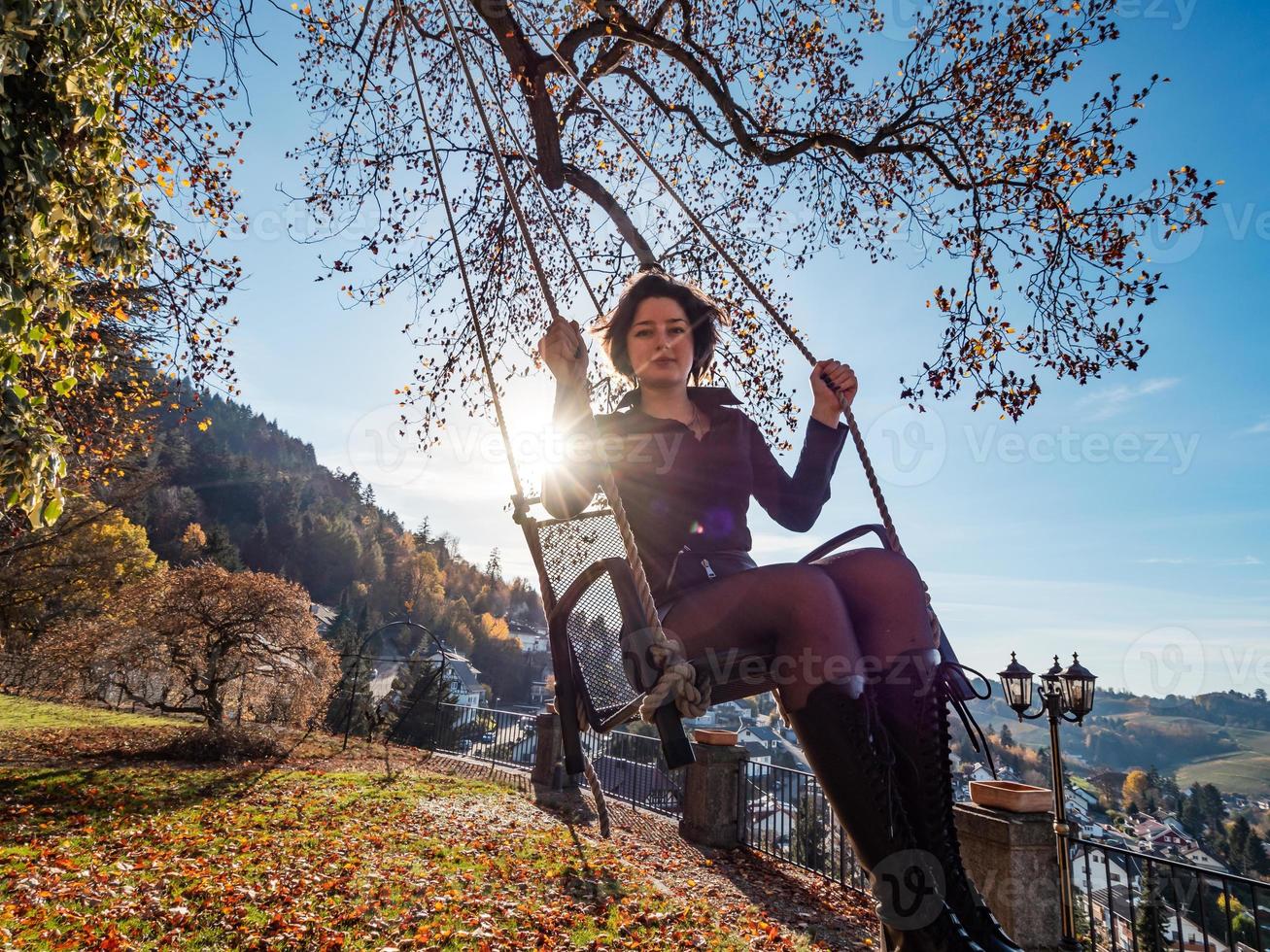 una niña se balancea en un columpio. día soleado. foto