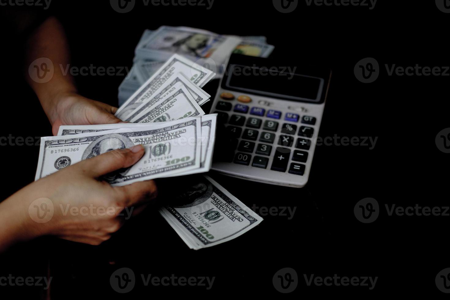 women hand counting money on a stack of 100 US dollars banknotes lots of money photo