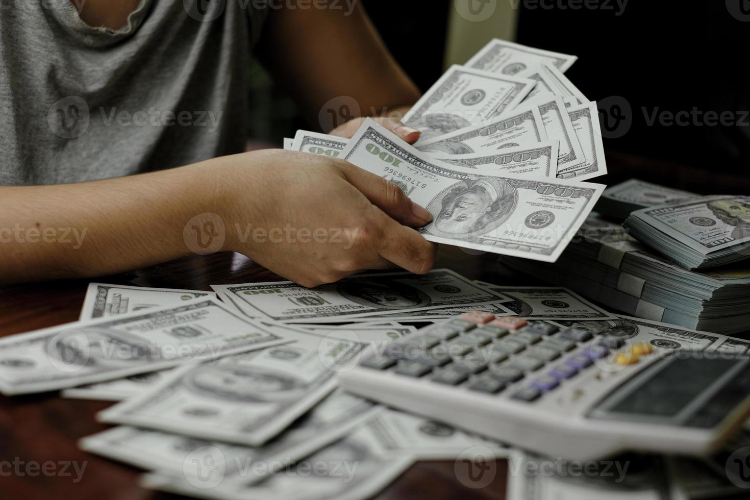 Businessmen women counting money on a stack of 100 US dollars banknotes lots of money photo