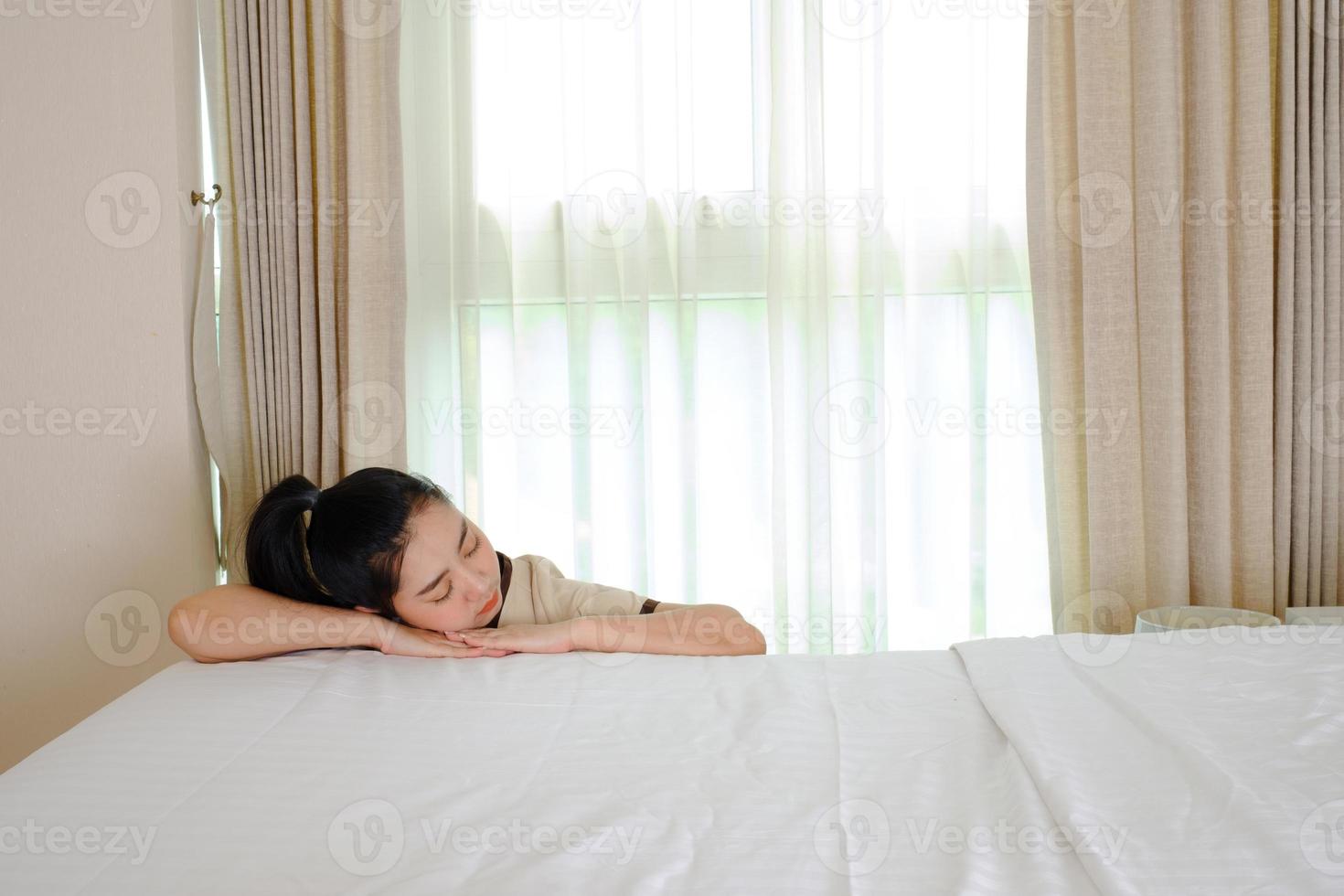 housemaid falling asleep on a bed in the bedroom of the hotel room photo