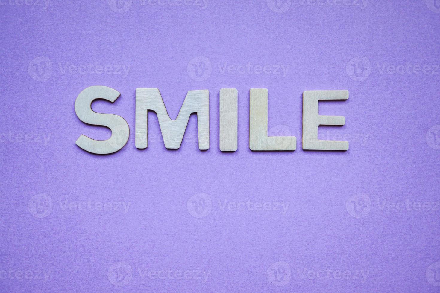 smile word with wooden letters on the purple background photo