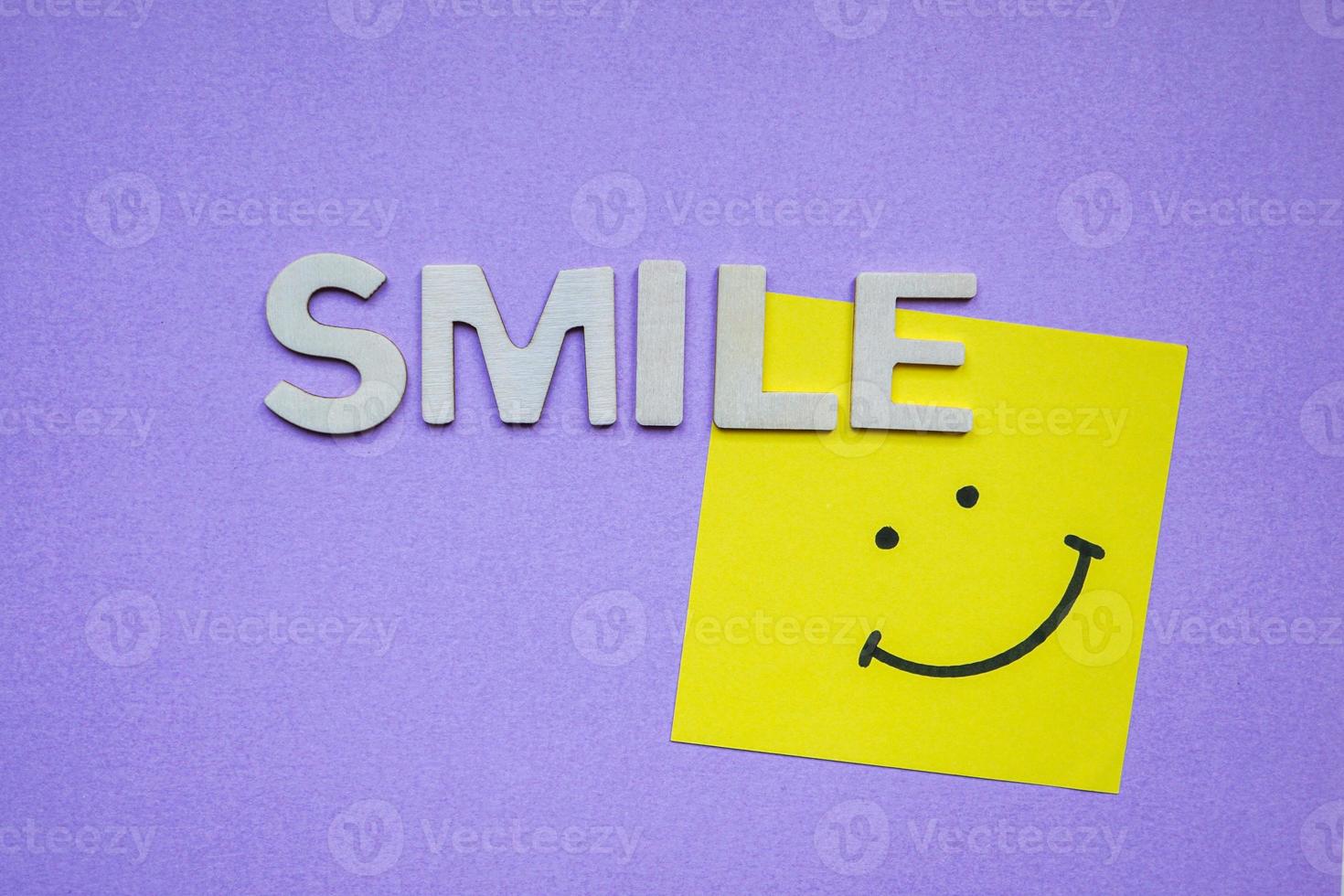 smile word with wooden letters on the purple background photo