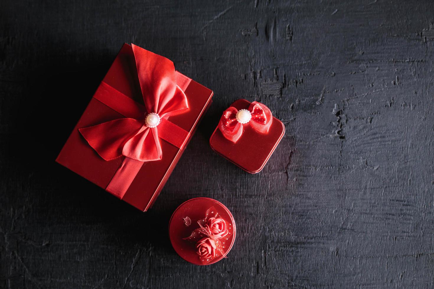 Caja de regalo roja sobre fondo de madera negra foto