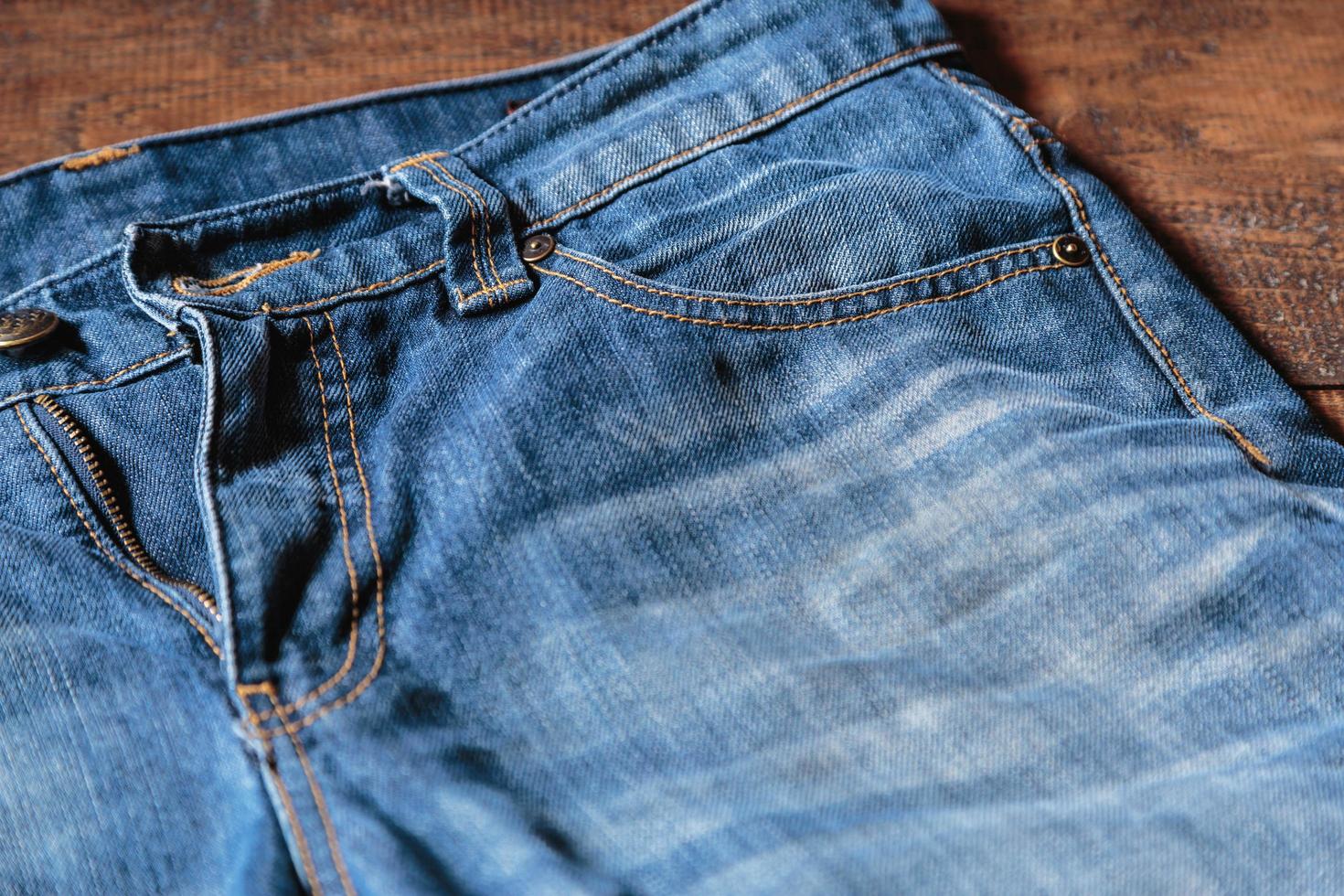 Pantalones de mezclilla azul jeans para hombre sobre fondo de madera. concepto de ropa de moda. foto