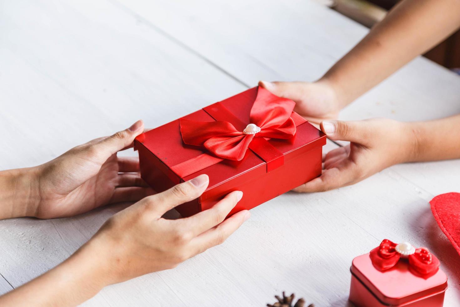 mano de persona joven dando decoración de caja de regalo foto