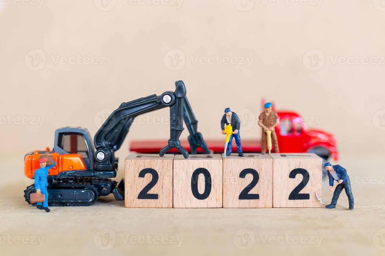 El equipo de trabajadores de personas en miniatura crea un bloque de madera número 2022 foto