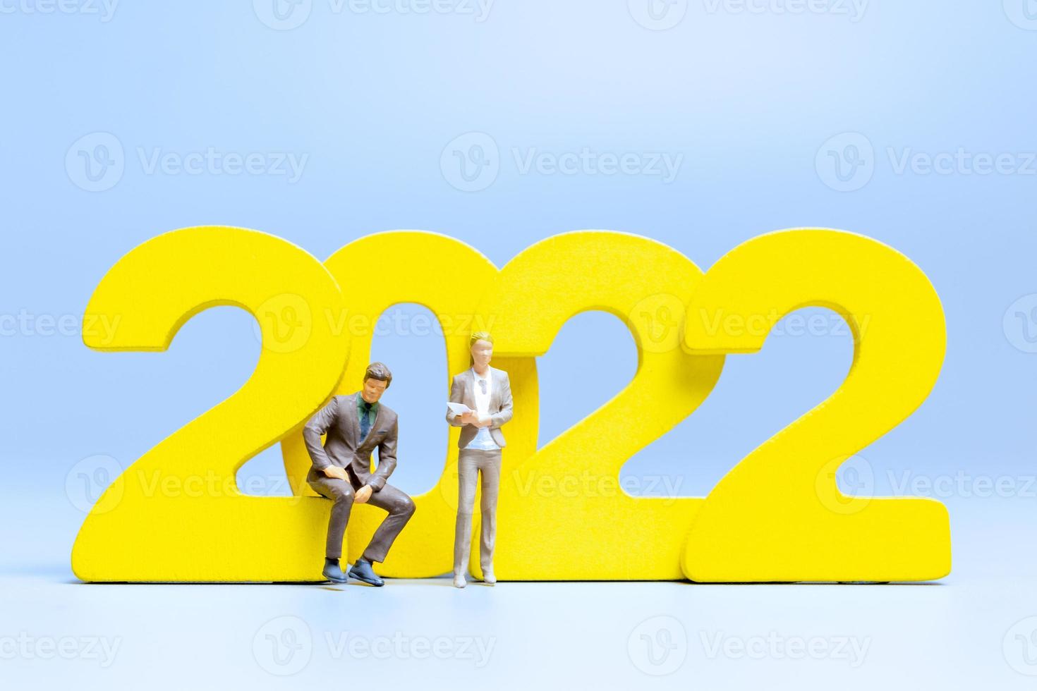 Miniature people Business people standing on number 2022 photo